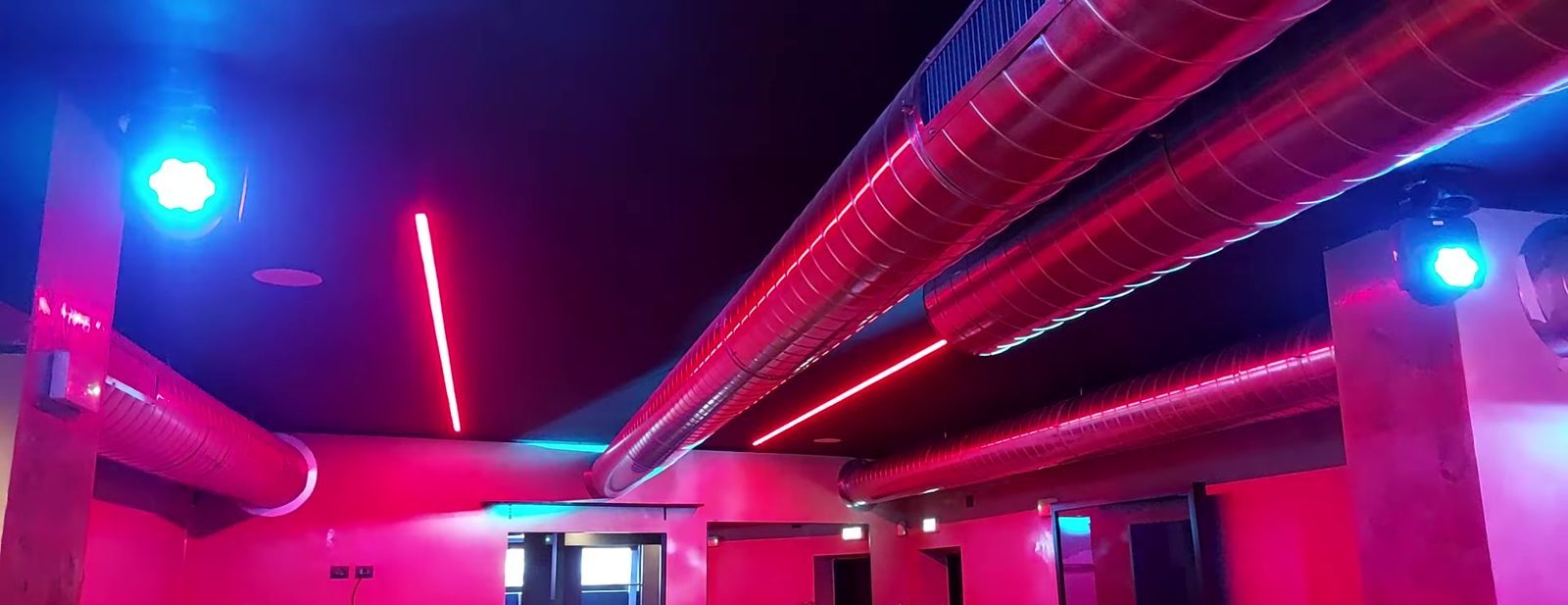 Locale notturno con profili LED a soffitto e luci scenografiche